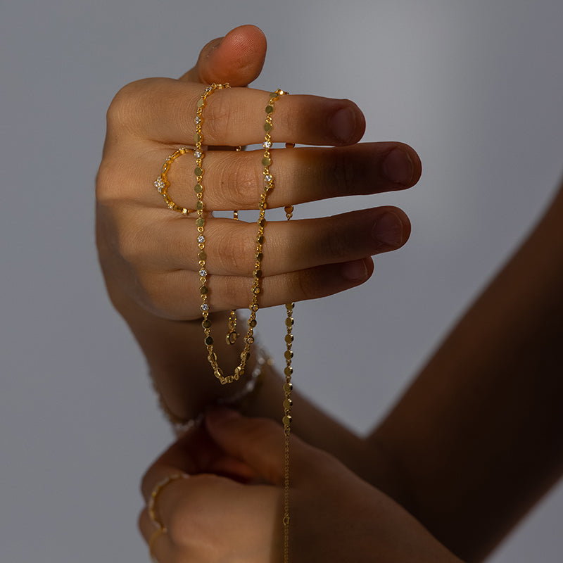Golden necklace and ring in ambient lighting