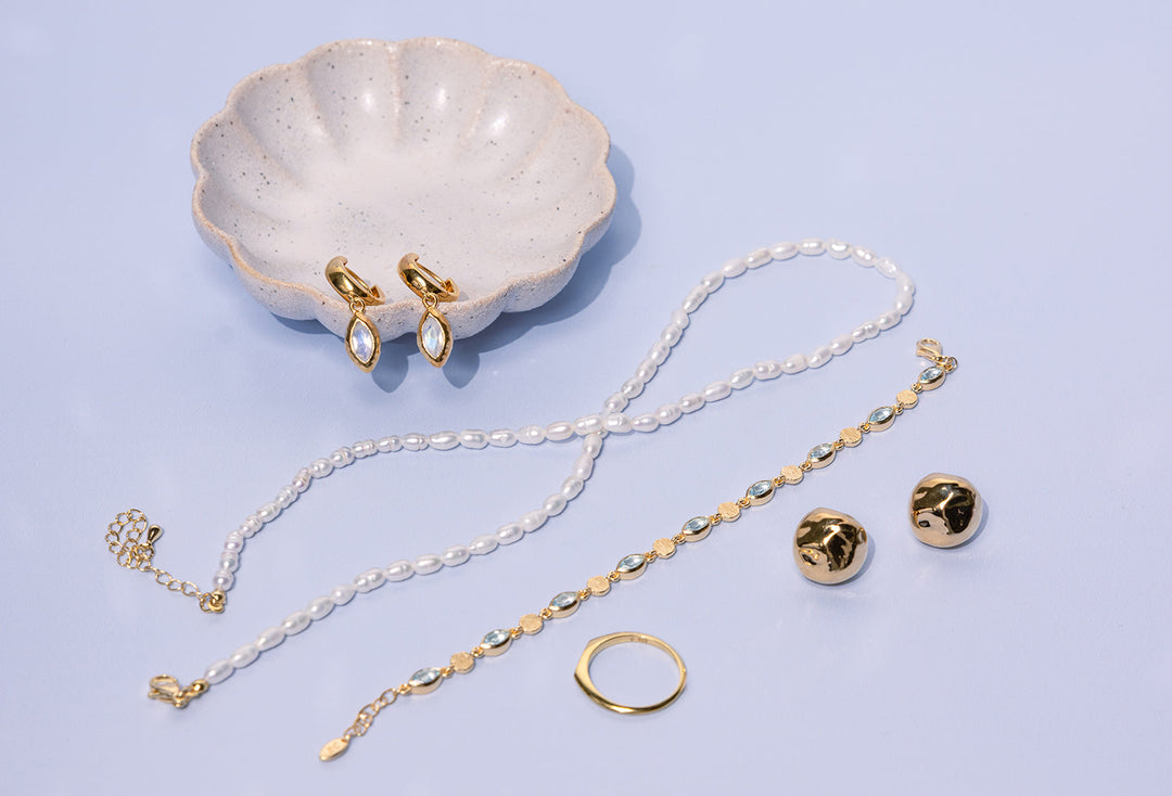 Jewellery flatlay featuring gold ToniMay Belle Moonstone Huggies