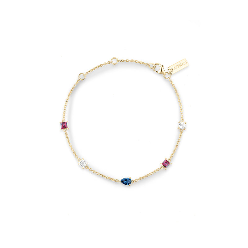 A delicate gold chain bracelet with five small accent stones in pink, blue, and clear settings, displayed on a clean white background. A small gold tag on the chain reads 'TONIMAY'.
