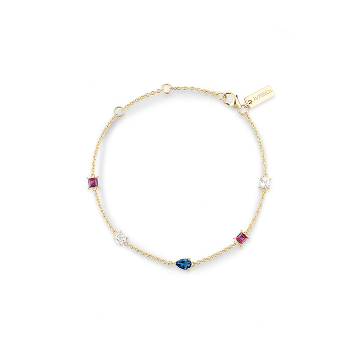 A delicate gold chain bracelet with five small accent stones in pink, blue, and clear settings, displayed on a clean white background. A small gold tag on the chain reads 'TONIMAY'.