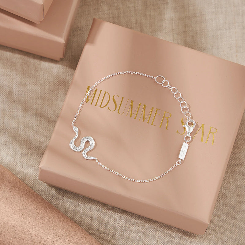 Silver bracelet on a 'Midsummer Star' branded box with beige fabric background
