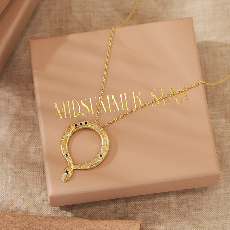 Gold necklace with a unique pendant on a 'MIDSUMMER STAR' box.
